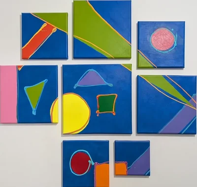 A wall arrangement of eight blue abstract canvases with colorful geometric forms.